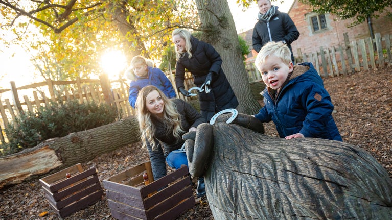 Multi-generational family playing with horseshoes on the trail in Charlecote's Spinney
